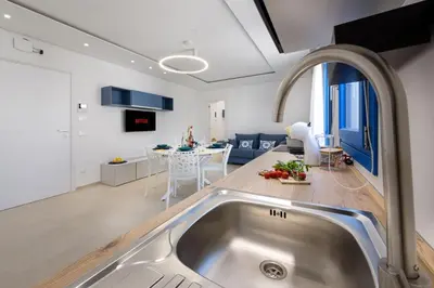 a kitchen and living room with a sink and a table at Residence Mazzini in San Vito lo Capo