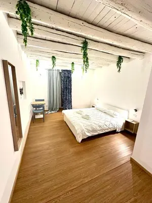 a bedroom with a bed and a table in a room at Cala Peppa Apartments in Palermo