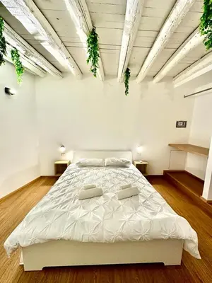 a bedroom with a large white bed in a room at Cala Peppa Apartments in Palermo