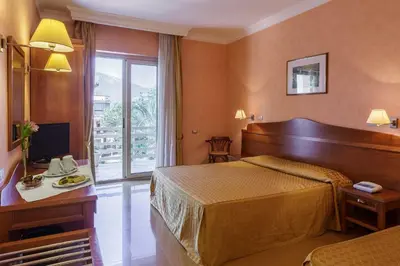 a hotel room with a bed and a television at Hotel Conchiglia d'Oro in Mondello