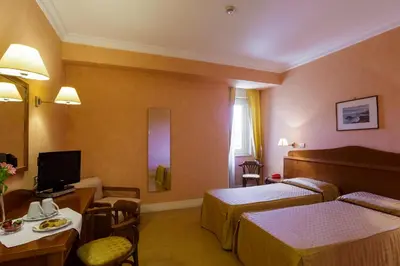 a hotel room with two beds and a television at Hotel Conchiglia d'Oro in Mondello