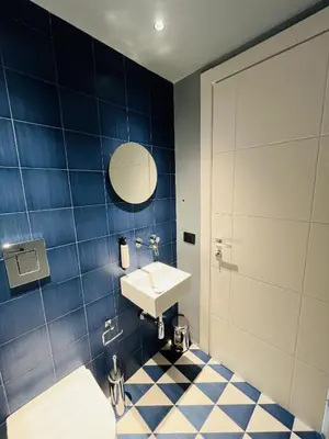 a bathroom with a sink and a blue tiled wall at Marina Boutique Rooms in Carini