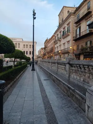 a street in a city with buildings and a light pole at Difronte Palatina Chapel in Palermo