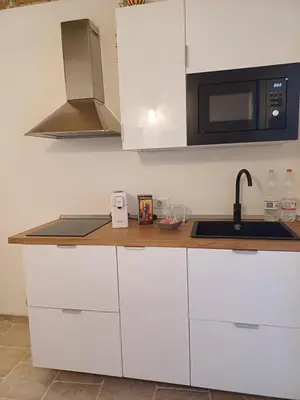 a kitchen with white cabinets and a sink and a microwave at Difronte Palatina Chapel in Palermo