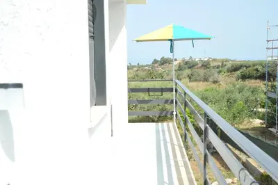 an umbrella on the balcony of a house at La Via Del Mare in Partinico