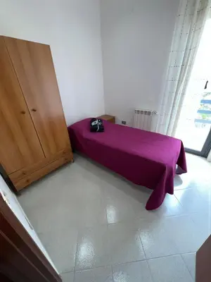 a bedroom with a bed with a purple blanket at La Via Del Mare in Partinico