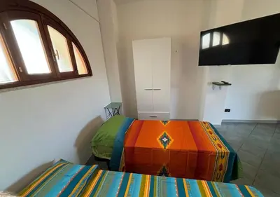 a bedroom with a bed with a colorful blanket at Maison Lume in Castellammare del Golfo