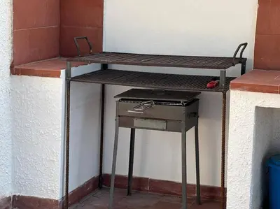 a table with a grill next to a refrigerator at Maison Lume in Castellammare del Golfo