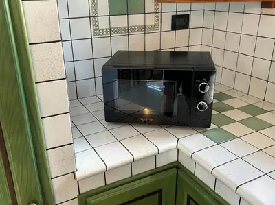 a toaster oven on a tiled wall in a kitchen at Maison Lume in Castellammare del Golfo