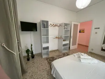 a room with a bed and a tv and shelves at Casa dei nonni di Yuri in Palermo
