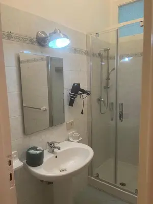 a bathroom with a sink and a shower with a mirror at Casa dei nonni di Yuri in Palermo