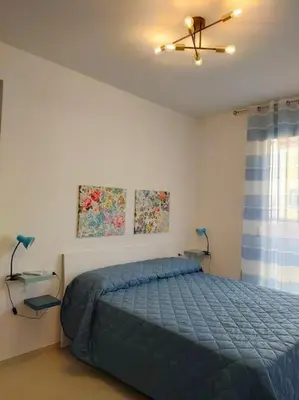 a bedroom with a blue bed and two lamps at Casa3Fratelli, via Cutino 16 in Isola delle Femmine
