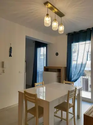 a dining room with a white table and chairs at Casa3Fratelli, via Cutino 16 in Isola delle Femmine
