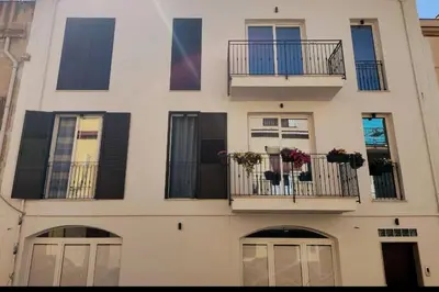 a tall building with balconies and windows with flowers on them at Casa3Fratelli, via Cutino 16 in Isola delle Femmine