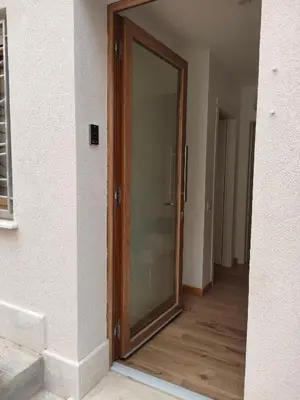 a sliding glass door in a room with a wooden floor at DH Studio Apartments in Castellammare del Golfo