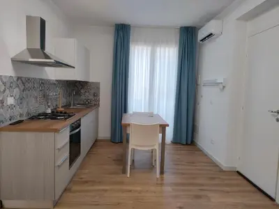 a kitchen with a table and a stove top oven at DH Studio Apartments in Castellammare del Golfo
