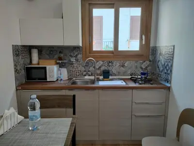 a kitchen with a sink and a microwave at DH Studio Apartments in Castellammare del Golfo