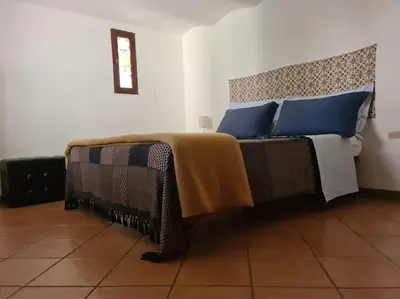 a bedroom with a bed with blue pillows at Casa e Putia Apartment in Palermo