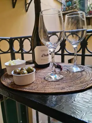 a table with two wine glasses and a bottle of wine at Casa e Putia Apartment in Palermo