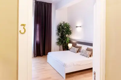 a bedroom with a white bed and a plant at Diletti Rooms in Palermo