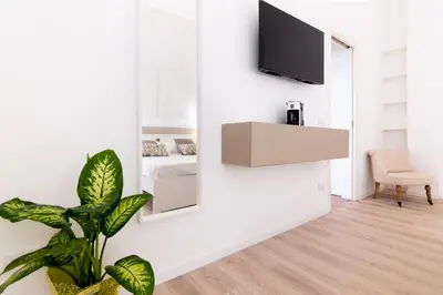 a living room with a mirror and a plant at Diletti Rooms in Palermo