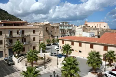 a view of a city with palm trees and buildings at Appartamento Le Terrazze in Castellammare del Golfo