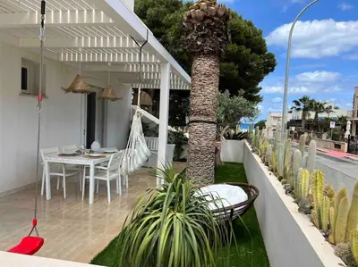 a patio with a table and chairs and a palm tree at Villa Ippolita - 2 Bedrooms Apartment with Exclusive Garden in San Vito lo Capo