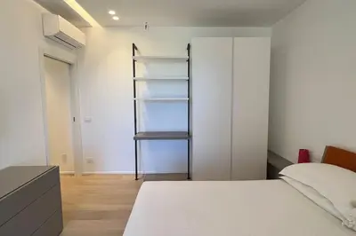 a bedroom with a white bed and a closet at Villa Ippolita - 2 Bedrooms Apartment with Exclusive Garden in San Vito lo Capo