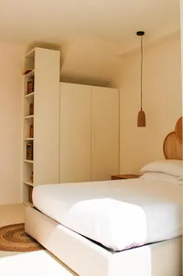a bedroom with a white bed and a book shelf at Villa Ippolita - 2 Bedrooms Apartment with Terrace & Garden Exclusive in San Vito lo Capo