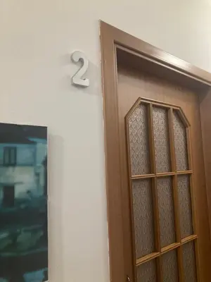 a wooden door with a number on the wall at Casa Paradiso in Palazzo Adriano