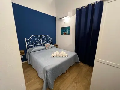 a bedroom with a bed with a blue wall at Ricasoli28Apartaments in Palermo