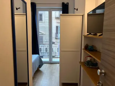 a room with a door with a window and a television at Ricasoli28Apartaments in Palermo