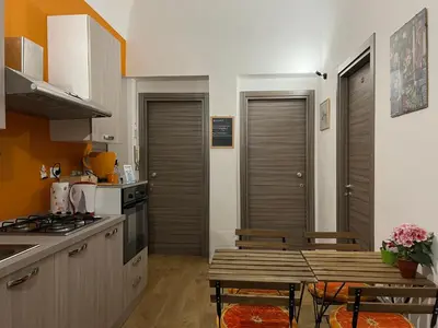 a kitchen with a wooden table and a kitchen with a stove at Ricasoli28Apartaments in Palermo