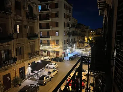 a view of a city street at night with cars parked at Ricasoli28Apartaments in Palermo