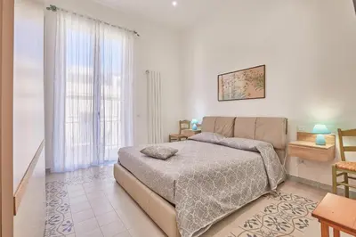 a bedroom with a bed and a large window at Zia Marì Casa Vacanze in Palermo