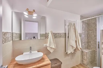 a bathroom with a sink and a mirror and a shower at Zia Marì Casa Vacanze in Palermo
