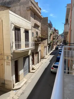 a building with two garage doors and a balcony at Casa Salvia in Alcamo