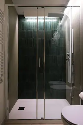 a shower with a glass door in a bathroom at Ai Materassai Apartments Palermo in Palermo