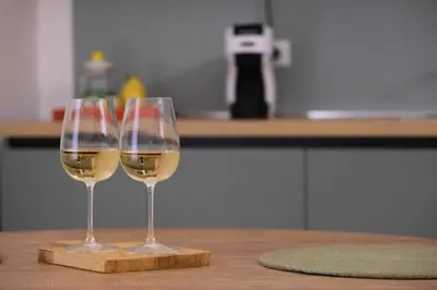 two glasses of white wine sitting on a wooden table at Ai Materassai Apartments Palermo in Palermo