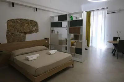 a bedroom with a bed with two towels on it at Ai Materassai Apartments Palermo in Palermo