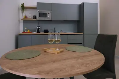 a wooden table with two glasses of wine at Ai Materassai Apartments Palermo in Palermo