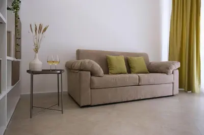 a couch with two green pillows in a living room at Ai Materassai Apartments Palermo in Palermo
