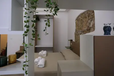 a living room with a couch with a plant at Ai Materassai Apartments Palermo in Palermo