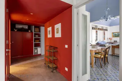a dining room with red walls and a table at Palazzo Fatta Apartment by DomuSicily in Palermo