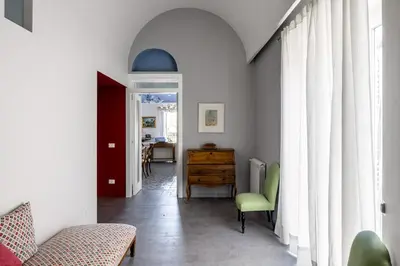 a living room with a green chair and a table at Palazzo Fatta Apartment by DomuSicily in Palermo