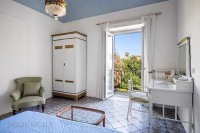 a bedroom with a bed and a desk and a window at Palazzo Fatta Apartment by DomuSicily in Palermo