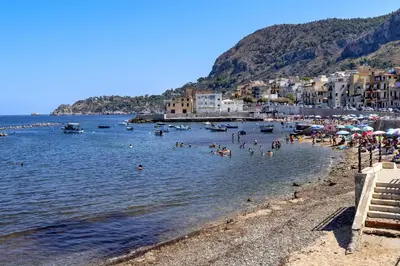 a group of people swimming in the water at a beach at B&B La Dimora di Poseidone in Bagheria