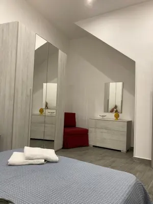 a bedroom with a bed and a red chair at Casalabruto in Bagheria