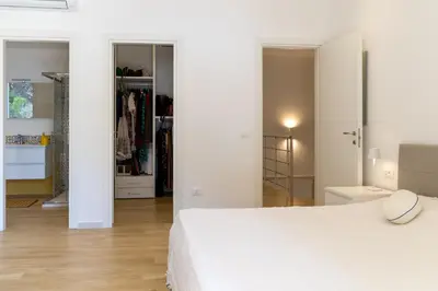 a white bedroom with a white bed and a closet at Casa cancello a mare in Santa Flavia