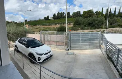 a white car is parked in a parking lot at Casa cancello a mare in Santa Flavia